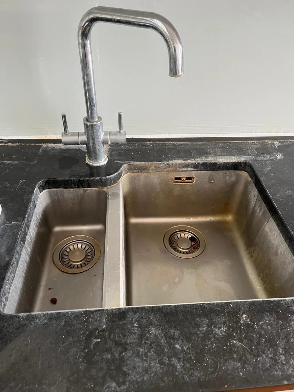 Stainless steel double sink dull with grease and watermarks before cleaning